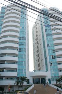 two tall buildings with palm trees in front of them at Apartamento semi penhouse in Cartagena de Indias