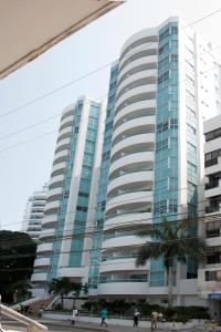 a tall building with a palm tree in front of it at Apartamento semi penhouse in Cartagena de Indias