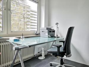 ein Büro mit einem Schreibtisch mit einem Drucker und einem Stuhl in der Unterkunft Private Room Zelinskij in München