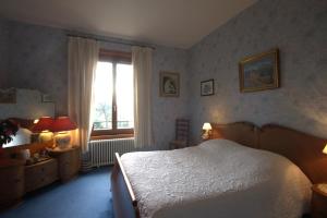 1 dormitorio con cama blanca y ventana en Petit Manoir du Bosc, en La Neuville-du-Bosc