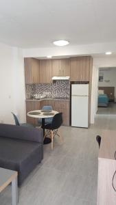 a living room with a couch and a table and a kitchen at Manoli Apartments in Ayia Napa