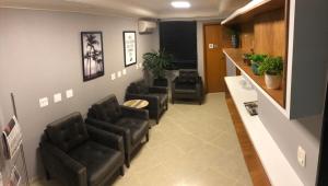 a waiting room with four chairs and a barber shop at Atlantico Inn Apart Hotel in Santos