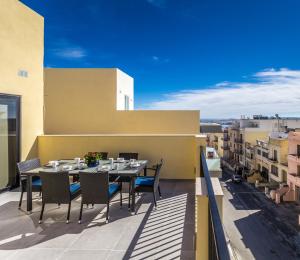un patio con tavolo e sedie su un balcone di Sunny Modern Apartments a Mellieħa