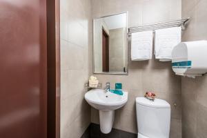 a bathroom with a sink and a toilet and a mirror at Hotel 81 Balestier in Singapore