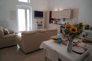 een woonkamer met een bank en een tafel met bloemen bij Vista Incantata - casa Bardaro in Matera
