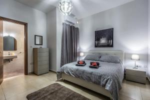 - une chambre avec un lit et une salle de bains pourvue d'un lavabo dans l'établissement Sunny Modern Apartments, à Mellieħa