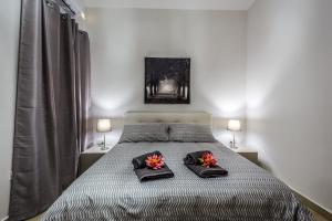 una camera da letto con un letto con due cuscini e fiori di Sunny Modern Apartments a Mellieħa