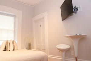 a bedroom with a bed and a tv on the wall at Charming & Stylish Studio on Beacon Hill #11 in Boston