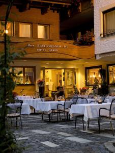restauracja ze stołami i krzesłami przed budynkiem w obiekcie Hotel Alpenrose w mieście Au