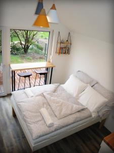 Bett in einem Zimmer mit einem Fenster und einem Tisch in der Unterkunft Mamut Stay in Kamnik
