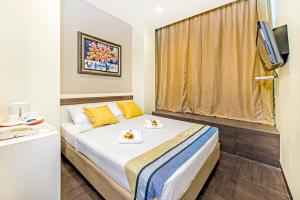um quarto de hotel com uma cama e uma televisão em Hotel 81 Bugis em Singapura
