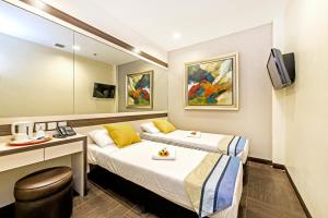 Habitación de hotel con 2 camas y escritorio en Hotel 81 Bugis en Singapur