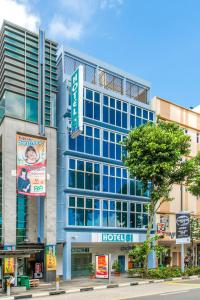 a large blue building with a hospital sign on it at Hotel 81 Bugis in Singapore