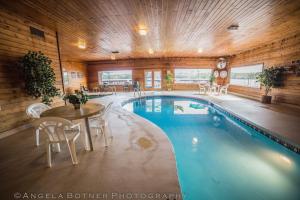 een zwembad in een huis met een tafel en stoelen bij St. Croix Inn in Solon Springs