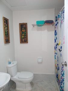 y baño con aseo blanco y lavamanos. en Anya and Carl's Comfy en Isla de Mactán