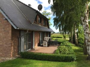 a brick house with a patio in the yard at Lottis Utkiek in Middelhagen