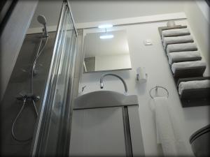 Un baño con lavabo, ducha y toallas. en Mamut Stay, en Kamnik