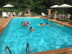 a group of people in a swimming pool at Hotel Solar dos Montes in Santana dos Montes