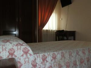 1 dormitorio con 1 cama con colcha de flores en Hostal Restaurante San Poul, en Consuegra