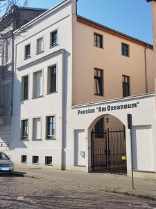 ein weißes Gebäude mit einem Tor davor in der Unterkunft Pension Am Ozeaneum in Stralsund