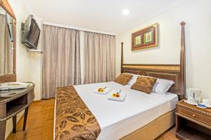 a hotel room with a bed with two plates of food on it at Hotel 81 Chinatown in Singapore