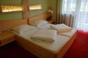 1 Schlafzimmer mit 2 Betten mit weißer Bettwäsche und Kissen in der Unterkunft Hotel Böhmerwaldhof in Ulrichsberg