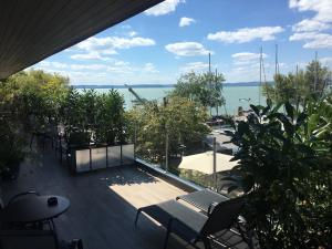 a balcony with chairs and a view of the water at Calypso Lakeside Rooms & Lux Apartments in Siófok