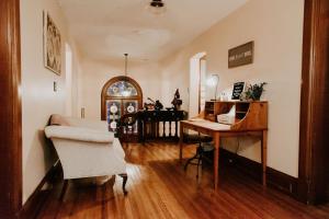 a living room with a desk and a bed and a table at Georges on York Boutique Inn in Taneytown