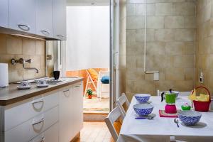 una cucina con tavolo e ciotole blu e verdi di TriesteHost - Via Torino a Trieste Altre 13 foto