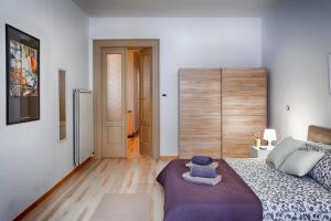 een slaapkamer met een bed met een paarse deken bij TriesteHost - Via Torino in Trieste