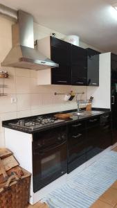 a kitchen with a black stove and a sink at Casa da Cris in Cotelo