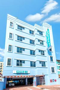 a white hotel with a sign on the front of it at Hotel 81 Geylang in Singapore