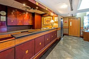 a kitchen with wooden cabinets and a counter top at Hotel 81 Geylang in Singapore