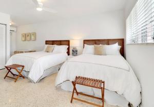 two beds in a bedroom with white walls at The Gondolier Inn in Naples