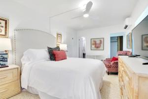 ein weißes Schlafzimmer mit einem großen Bett und einem Badezimmer in der Unterkunft The Gondolier Inn in Naples
