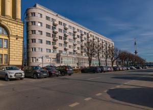 un gran edificio con coches aparcados en el lateral de una calle en Квартира с видом на Неву, en San Petersburgo