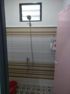 a shower in a bathroom with a window at Anis Homestay Kuala Perlis in Kuala Perlis