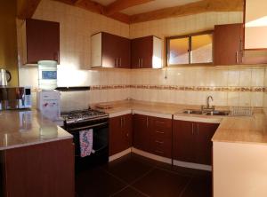 a kitchen with a sink and a stove top oven at Hostal Pablito 2 in San Pedro de Atacama