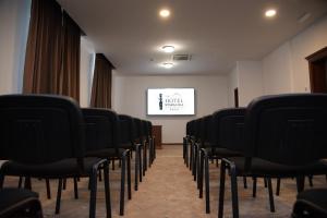 a row of chairs in a room with a screen at Hotel Stara Lika in Gospić