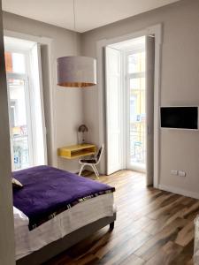 sypialnia z łóżkiem, stołem i oknami w obiekcie Città del sole b&b Napoli w mieście Neapol