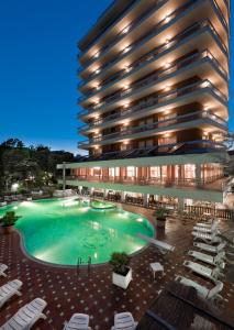 un hotel con una gran piscina frente a un edificio en Hotel Gambrinus - Valentini Family Village, en Bellaria-Igea Marina