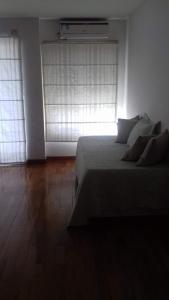 1 dormitorio con 1 cama y una ventana con calentador en Departamento Ciudad de la Paz en Buenos Aires