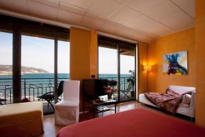 a bedroom with a room with a view of the ocean at Jasmin Charme Hotel in Diano Marina
