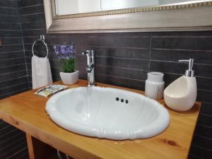 baño con lavabo blanco en una encimera de madera en Chill Out Jose Ignacio, en José Ignacio
