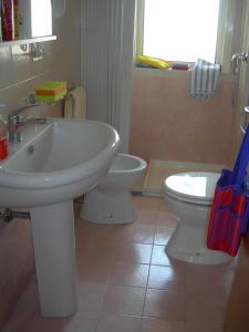 ein Badezimmer mit einem weißen Waschbecken und einem WC in der Unterkunft Appartamenti San Foca in San Foca
