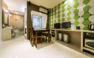 uma cozinha com uma mesa e uma parede verde e branca em Hotel Zara em Changwon