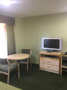 Habitación con mesa, TV, mesa y sillas. en Budget Inn - Laytonville, en Laytonville