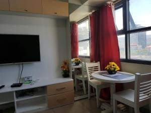 een woonkamer met een tv en een tafel en stoelen bij KC Studio 6 at Horizon 101 Cebu in Cebu City