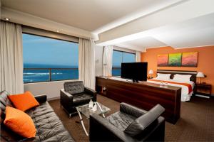 una camera d'albergo con letto e televisore di Gran Cavancha Suite a Iquique