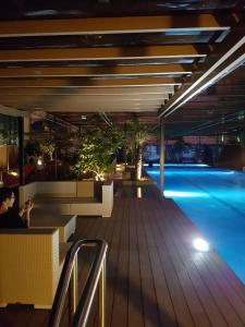 een zwembad 's nachts met een persoon aan een tafel bij KC Studio 6 at Horizon 101 Cebu in Cebu City
